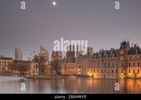 L'Aia - Febbraio 17 2019: L'Aia, le Neherlands. Il castello di Binnenhof, il Parlamento olandese, con lo stagno di corte, sullo sfondo dei grattacieli Foto Stock