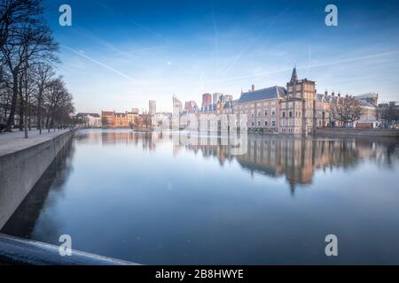 L'Aia - Febbraio 17 2019: L'Aia, le Neherlands. Il castello di Binnenhof, il Parlamento olandese, con lo stagno di corte, sullo sfondo dei grattacieli Foto Stock