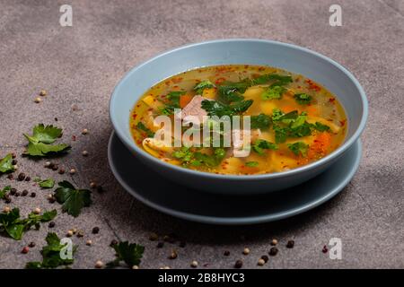 Deliziosa zuppa piccante con manzo e spaghetti su sfondo grigio. Foto Stock