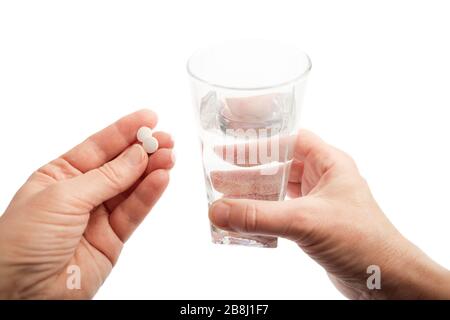 Mani di donna anziana con bicchiere d'acqua e pillole, isolate su sfondo bianco Foto Stock