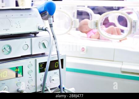 Apparecchiature mediche e un neonato in un incubatore Foto Stock