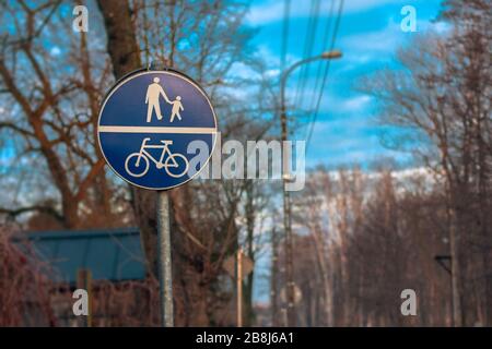 Segnali e segnali per ciclisti e pedoni. Cartelli stradali blu su sfondo primaverile. Foto Stock