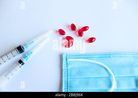 Pillole rosse e siringa di concetto medico. Prevenzione ARVI Foto Stock