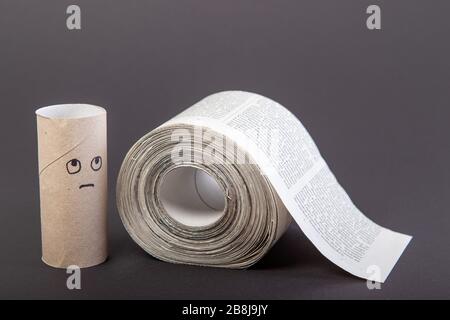 carta igienica composta da giornali, carta igienica alternativa, isolata su nero, rotolo di giornale, faccia triste su rotolo di carta igienica vuoto, primo piano Foto Stock