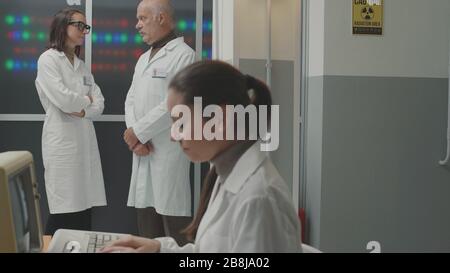 Team scientifico in stile vintage che lavora in laboratorio, lavorano e discutono insieme Foto Stock