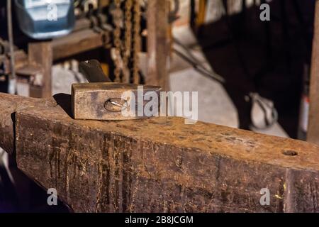 Martellare su un'incudine in un'officina Foto Stock