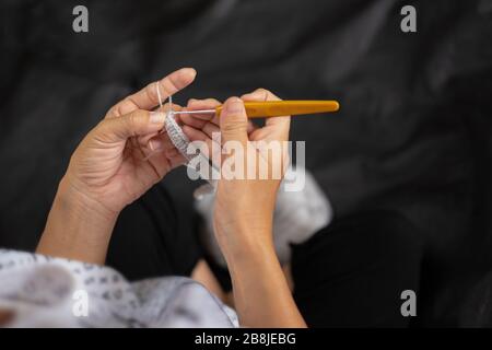 Primo piano di maglia donna mani, gancio a maglia femmina mano, crochet maglia donna, vista dall'alto Foto Stock