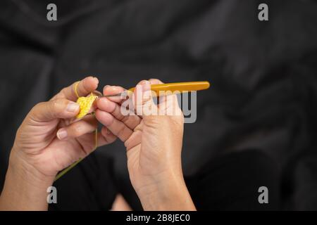 Primo piano di maglia donna mani, gancio a maglia femmina mano, crochet maglia donna, vista dall'alto Foto Stock