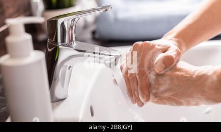 Lavare le mani con acqua calda e sapone. Prevenzione del coronavirus. Corona Virus (covid 19) protezione pandemica mediante lavaggio delle mani. Foto Stock