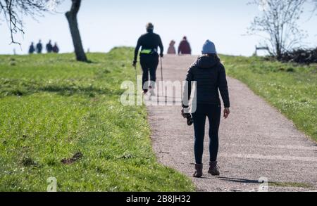 22 marzo 2020, Hessen, Francoforte sul meno: Gli escursionisti sono a distanza in un sole luminoso tra i campi nella periferia nord-orientale della città. Foto: Frank Rumpenhorst/dpa Foto Stock