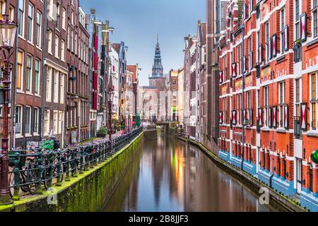 Amsterdam, Paesi Bassi canali e la torre della chiesa all'alba. Foto Stock