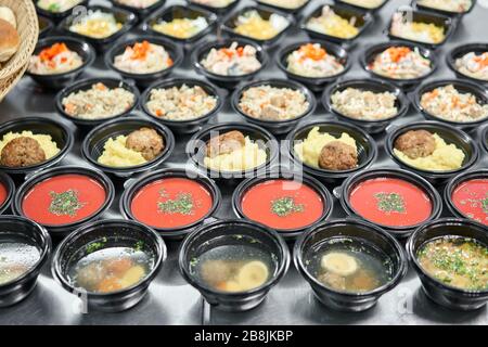 Fila di contenitori monouso in plastica per il pranzo con cibo sano  naturale. Minestre, minestra di panna, portata principale con contorno,  insalate. Consegna di cibo. Pranzo nel Foto stock - Alamy