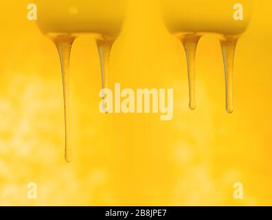 Schizzi di miele dolce biologico. Miele che si immerge dal cucchiaio di miele di legno Foto Stock