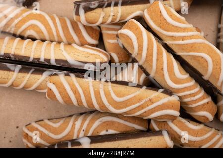 Bastoncini di biscotti ricoperti di cioccolato e glassa bianca. Primo piano Foto Stock