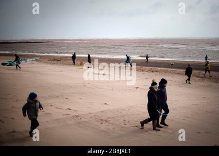 Escursionisti e kite surfers a Exmouth Beach, nonostante il governo che consiglia al pubblico di ridurre l'interazione sociale a causa dell'epidemia di coronovirus. Data foto: Domenica 22 marzo 2020. Guarda la storia della PA IN primavera. Il credito per le foto deve essere: Victoria Jones/PA Wire Foto Stock