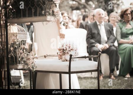 Matrimonio evento mazzo di fiori in giornata di sole con persone in background Foto Stock
