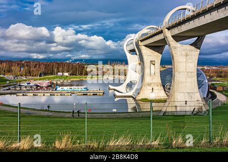 Una vista invernale generale dell'attrazione turistica Falkirk Wheel a Falkirk Scotland UK con barche ormeggiate nel bacino del canale Foto Stock