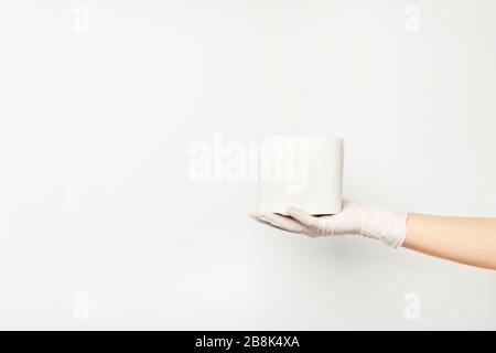 Una mano di donna che tiene l'ultimo rotolo di carta igienica. Foto Stock