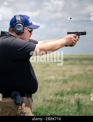 Pistola automatica a sparo con guscio espulso. Addestramento di armi e fuoco dal vivo a portata aperta. Gun culture America Fort Collins USA Foto Stock