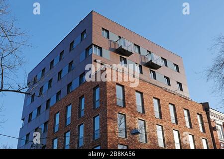 KHARKIV, UCRAINA 04 marzo 2020: Edificio in mattoni marroni con finestre e balconi vista dal basso. Un frammento di un edificio a più piani in mattoni. Foto Stock