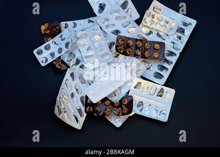 Svuotare la confezione da sotto le pillole su sfondo nero. Blister di pillole vista dall'alto. Molti farmaci usati. Foto Stock