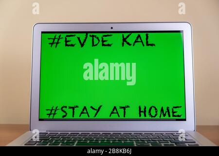 Scrivere un messaggio di attenzione sul promemoria del notebook geensscreen rimanere a casa (turco significa "Evde Kal"). Covid-19.Stay a casa in tempo di pandemic concetto. Foto Stock