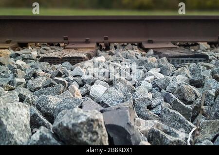 Vista laterale ad angolo basso del letto ferroviario con binari ferroviari Foto Stock