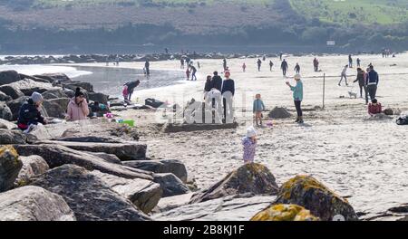 Rosscarbery, West Cork, Irlanda. 22 marzo 2020. Una bella giornata di sole ha portato fuori le famiglie durante la giornata della mamma godendo di un po' di aria fresca mentre si distende sulla spiaggia. Credit: Aphprospettive/Alamy Live News Foto Stock