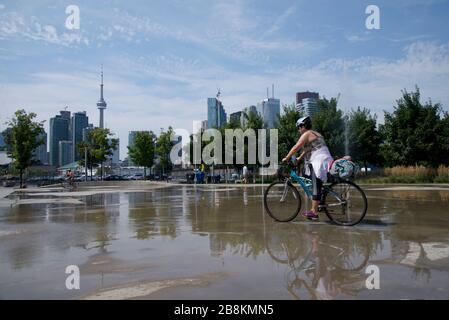 Passeggiate in bicicletta nel parco con Toronto cityscape come sfondo Foto Stock