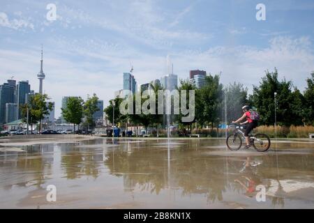 Passeggiate in bicicletta nel parco con Toronto cityscape come sfondo Foto Stock