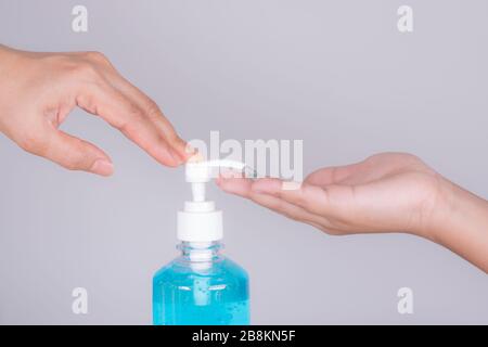 primo piano mano e ragazzo di madre applicando gel igienizzante sulle mani anti coronavirus o covid-19 in studio su sfondo bianco. Covid-19 di protezione esterno Foto Stock