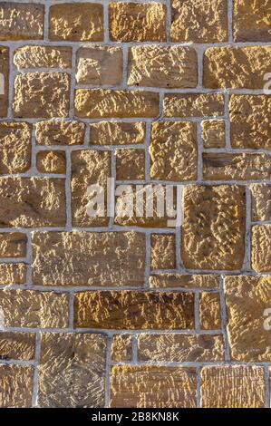 Muro di arenaria, in mattoni con pietra rustica affilata di diverse dimensioni e giunti bianchi Foto Stock