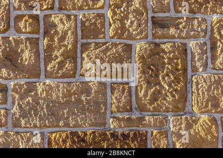 Muro di arenaria, in mattoni con pietra rustica affilata di diverse dimensioni e giunti bianchi Foto Stock