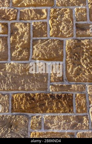 Muro di arenaria, in mattoni con pietra rustica affilata di diverse dimensioni e giunti bianchi Foto Stock