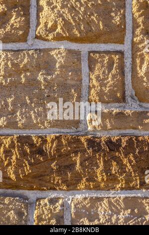 Muro di arenaria, in mattoni con pietra rustica affilata di diverse dimensioni e giunti bianchi Foto Stock