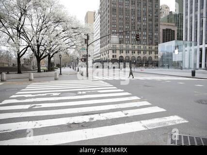 New York, Stati Uniti. 22 marzo 2020. Una donna attraversa un vuoto di pedoni e traffico 5th Avenue a New York City Domenica, 22 marzo 2020. New York state Gov. Andrew Cuomo ha detto che il numero di decessi correlati a Coronavirus nello stato è ora 114 e dei 15,168 casi positivi, 9,045 sono stati a New York City. Foto di John Angelillo/UPI Credit: UPI/Alamy Live News Foto Stock