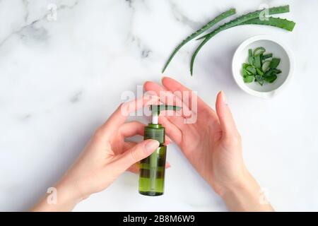 Bottiglia cosmetica con olio essenziale di aloe vera in mani femminili. Prodotto naturale di bellezza biologica, concetto di cura della pelle delle mani Foto Stock