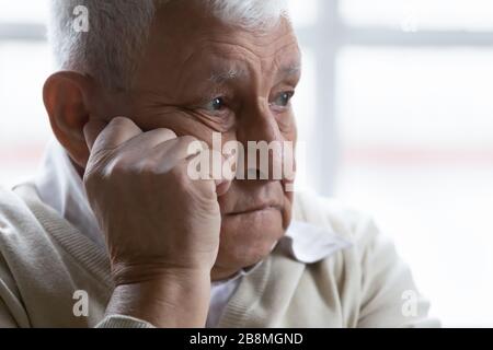 Primo piano vecchio uomo che si sente deluso e perso in pensieri tristi Foto Stock