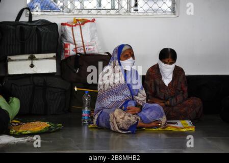 Guwahati, Assam, India. 22 marzo 2020. Passeggeri con maschera protettiva seduti alla stazione ferroviaria di Guwahati, a Guwahati. Credit: David Talukdar/ZUMA Wire/Alamy Live News Foto Stock