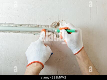 Un lavoratore sta tagliando la parte dell'isolamento con una fresa. Foto Stock