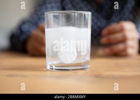 Chiudere il bicchiere d'acqua frizzante con la pillola effervescente che si dissolve Foto Stock