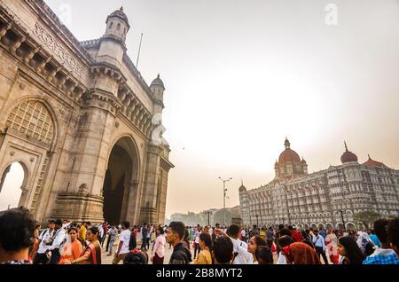 MUMBAI, INDIA – DEC. 8, 2019: Visitatori che godono vicino Gateway of India, di fronte alla principale attrazione turistica Taj Mahal Palace e Tower Hotel. Foto Stock