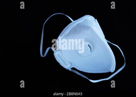 Maschera ffp3 bianca sterile non riutilizzabile con valvola su sfondo nero. Concetto per coronavirus covid-19, malattie respiratorie dovute ad allergie e A. Foto Stock