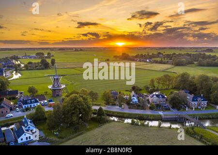 Veduta aerea del tramonto sul villaggio olandese in campagna agricola paesaggio, Groningen, Paesi Bassi. Foto Stock