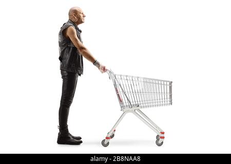 Foto di profilo a tutta lunghezza di un punk uomo in abiti in pelle in piedi con un carrello vuoto isolato su sfondo bianco Foto Stock