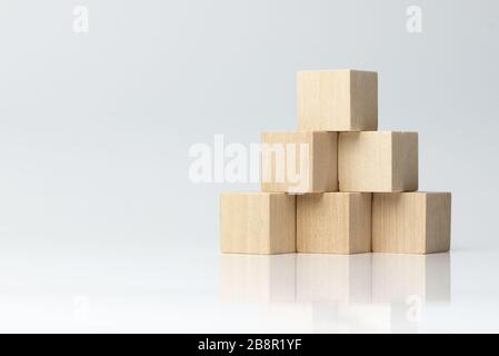 Sei blocchi di legno disposti a forma di piramide Foto Stock
