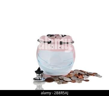 Piggy bank con maschera medica, monete e stetoscopio. Concetto di crisi finanziaria. Isolato su bianco con riflessione. Foto Stock