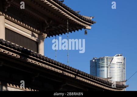 Roppongi Hills torre vista dietro il tetto di un santuario a Tokyo, Giappone. Foto Stock