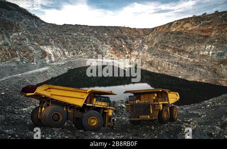 Dump di giallo il caricamento dei camion minerali di rame, argento, oro e altri a cava di data mining. Foto Stock