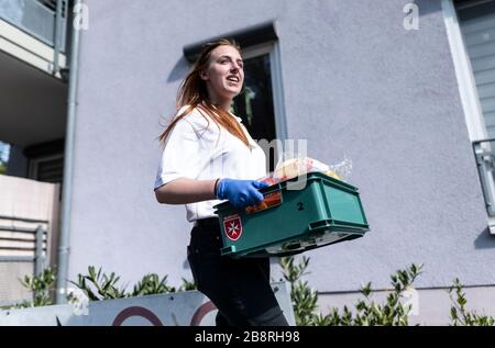 Friburgo, Germania. 20 Marzo 2020. Julia Gerst di Malteser Hilfsdienst trasporta il cibo in una scatola ad una casa. Entro tre giorni, il personale di Friburgo ha messo a punto un servizio di shopping e consegna per i bisognosi. Credit: Patrick Seeger/dpa/Alamy Live News Foto Stock